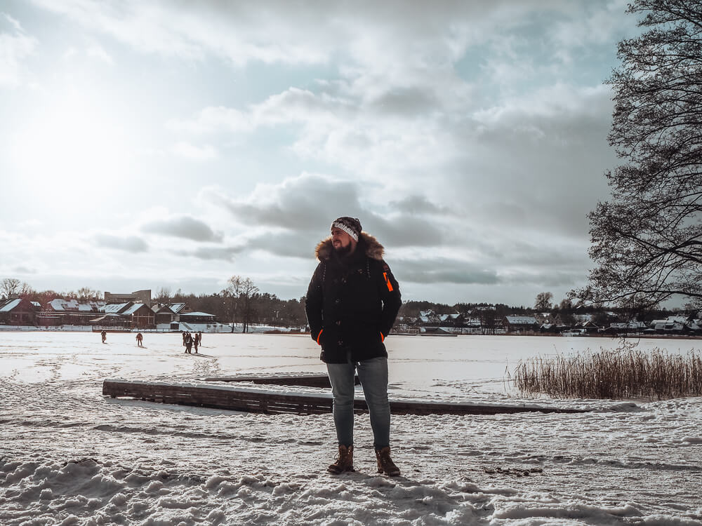 Man standing on a frozen lake at Trakai Castle in Lithuania