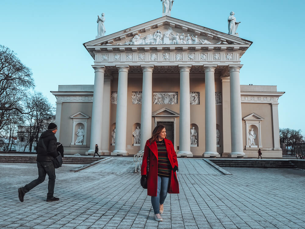 Woman in a red coat at Vilnius Town Hall and Vilnius Cathedral Square