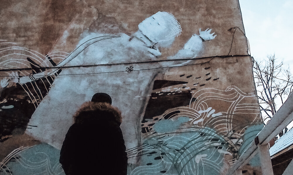 Man looking at unusual street art in Vilnius Lithuania