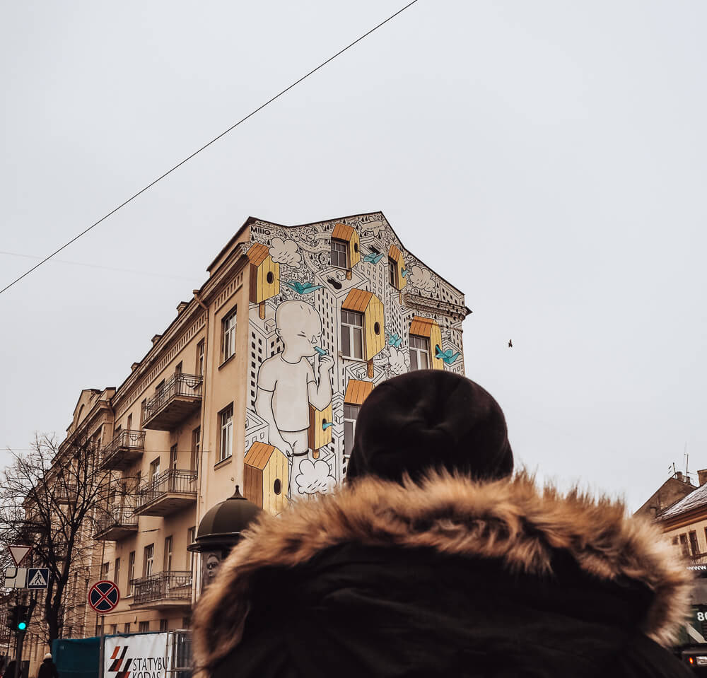 Man looking at street art in Vilnius Lithuania