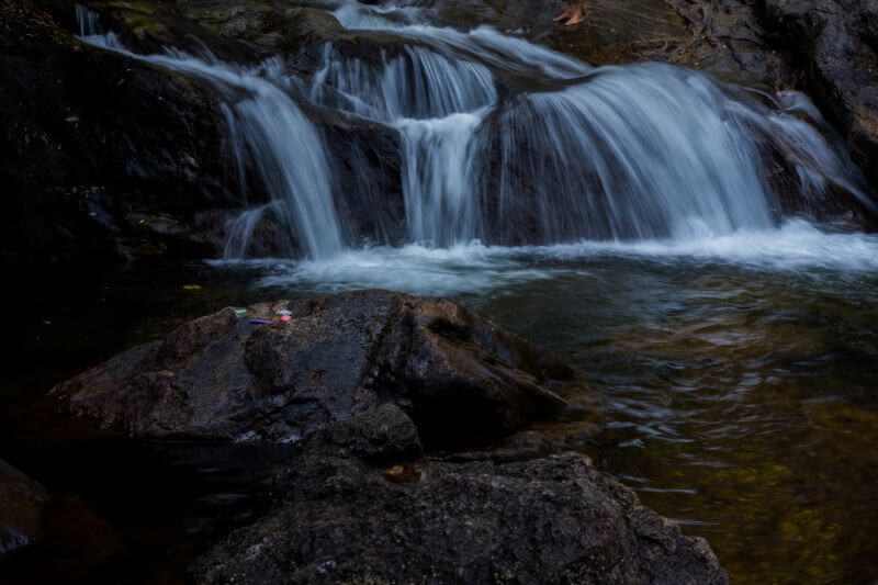 Majestic waterfall cascading down rocky cliffs surrounded by lush greenery in Munnar.