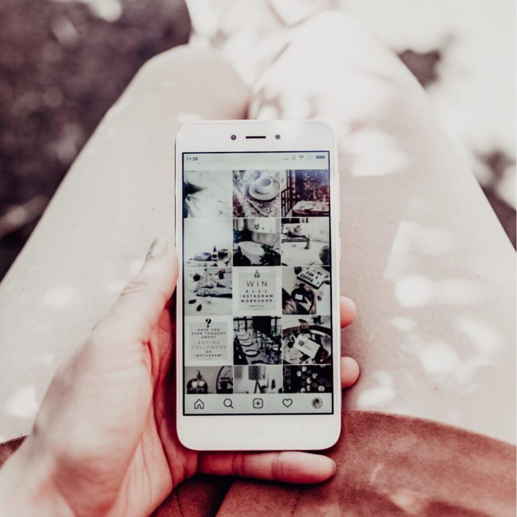 Image of a girl holding her phone open on her Instgram account