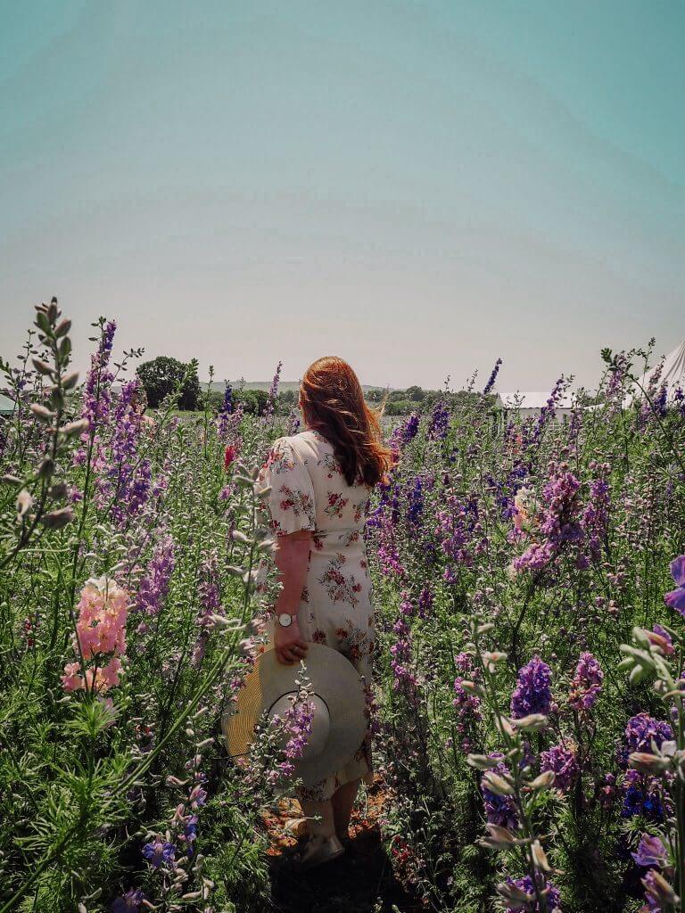 Woman with red hair standing in a flower field