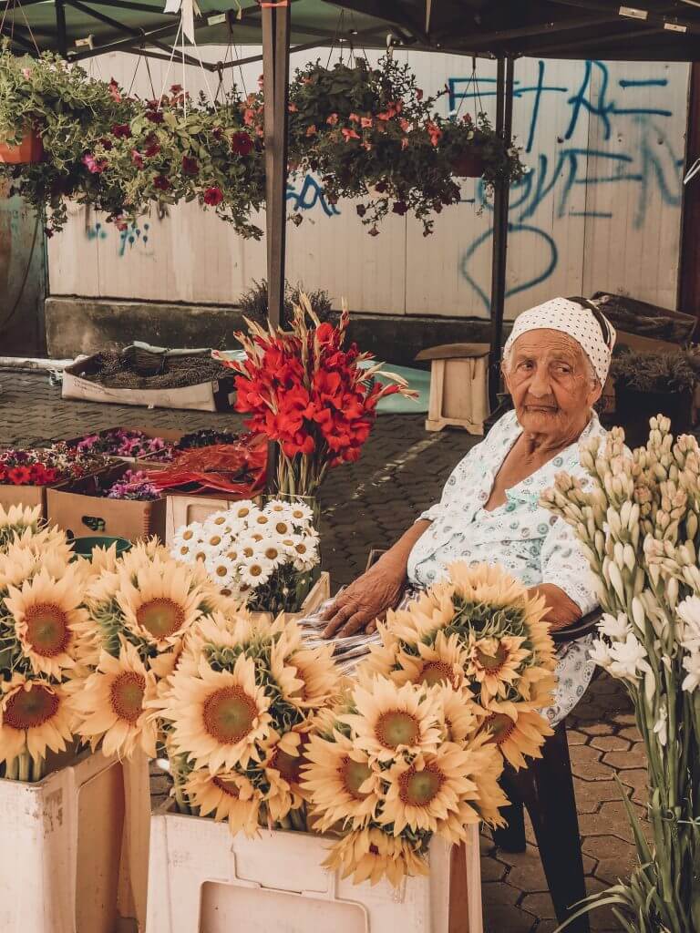 Romani woman in flower markets in Bucharest. Read more on www.ouruniquestays.com