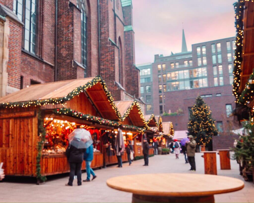 Rustic wooden huts with fairy lights at the St Petri Christmas markets
