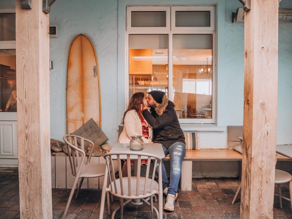Couple kissing beside a surf board at Armada Spanish Point Hotel Clare