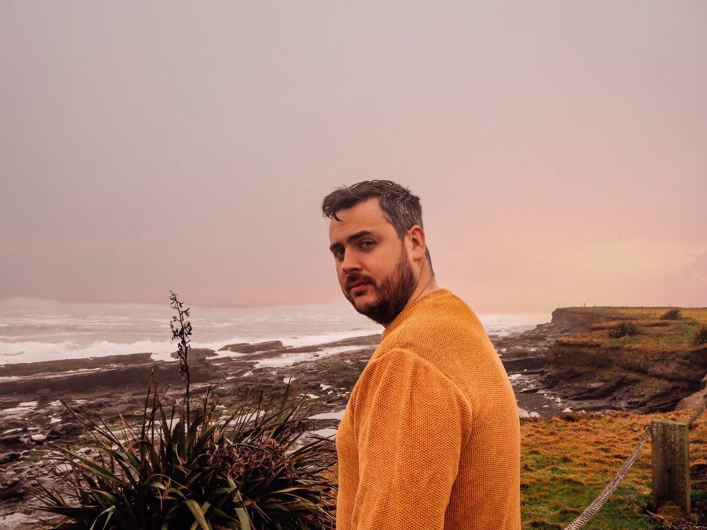 Man in a yellow jumper looking out at the Atlantic Ocean in County Clare Ireland