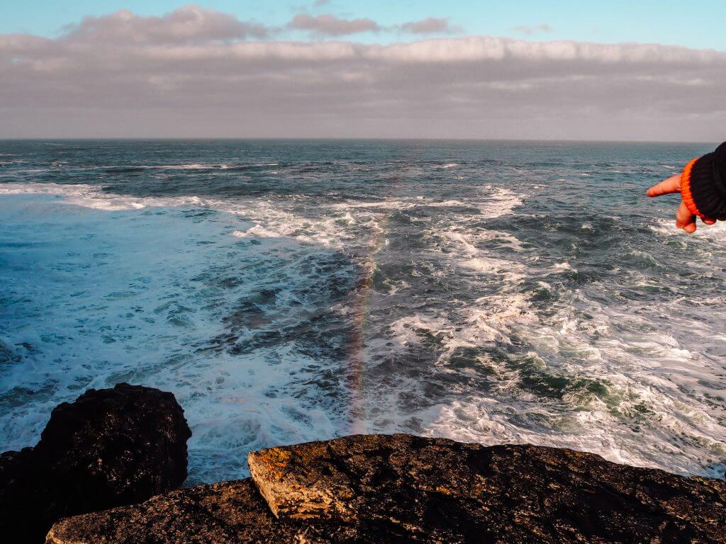 Rainbows in the spray of the ocean at Kilkee Cliffs Ireland.