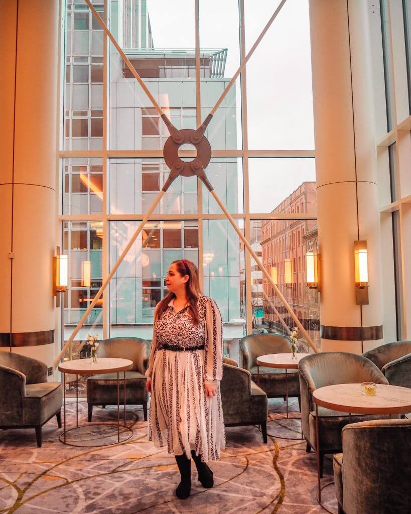 Woman in a white dress standing in the bar of the Grand Central Hotel Belfast