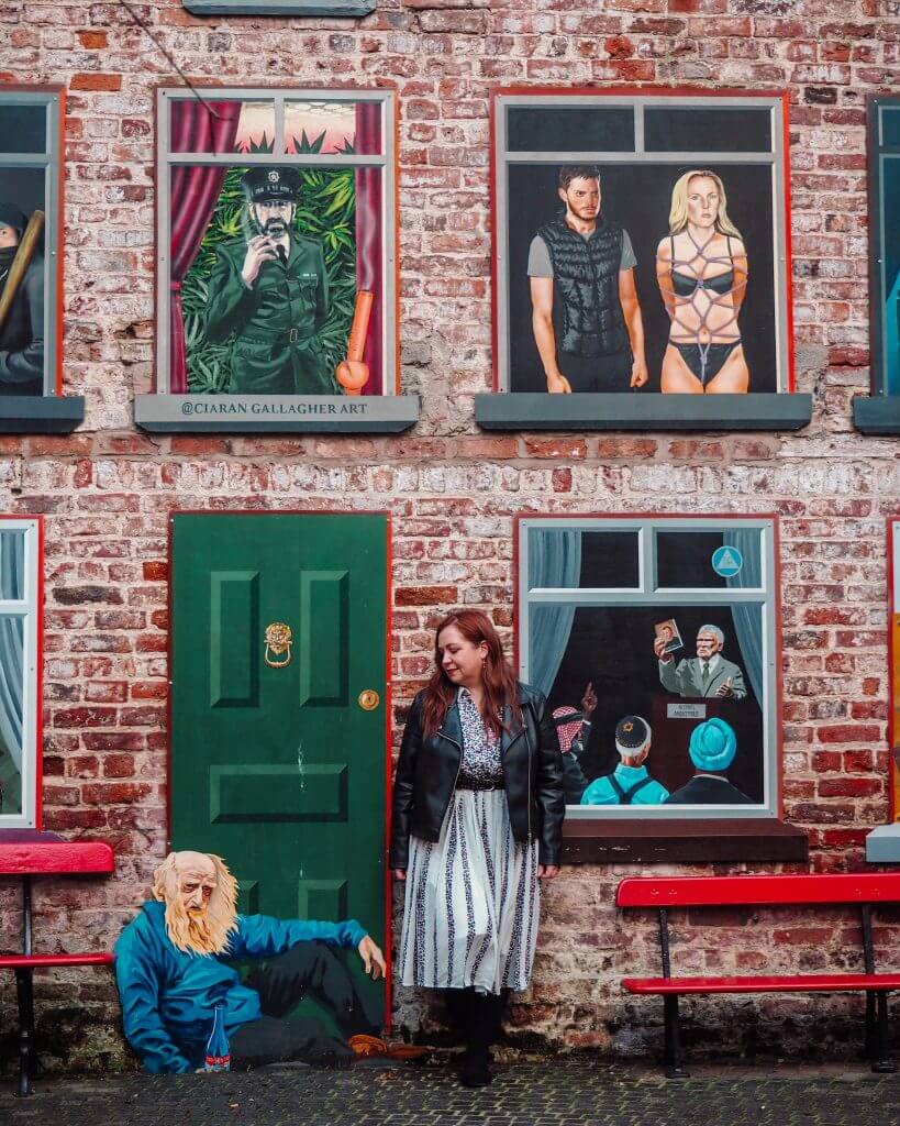 Woman standing beside street art at the Cathedral Quarter Belfast. Instagram spots Belfast.
