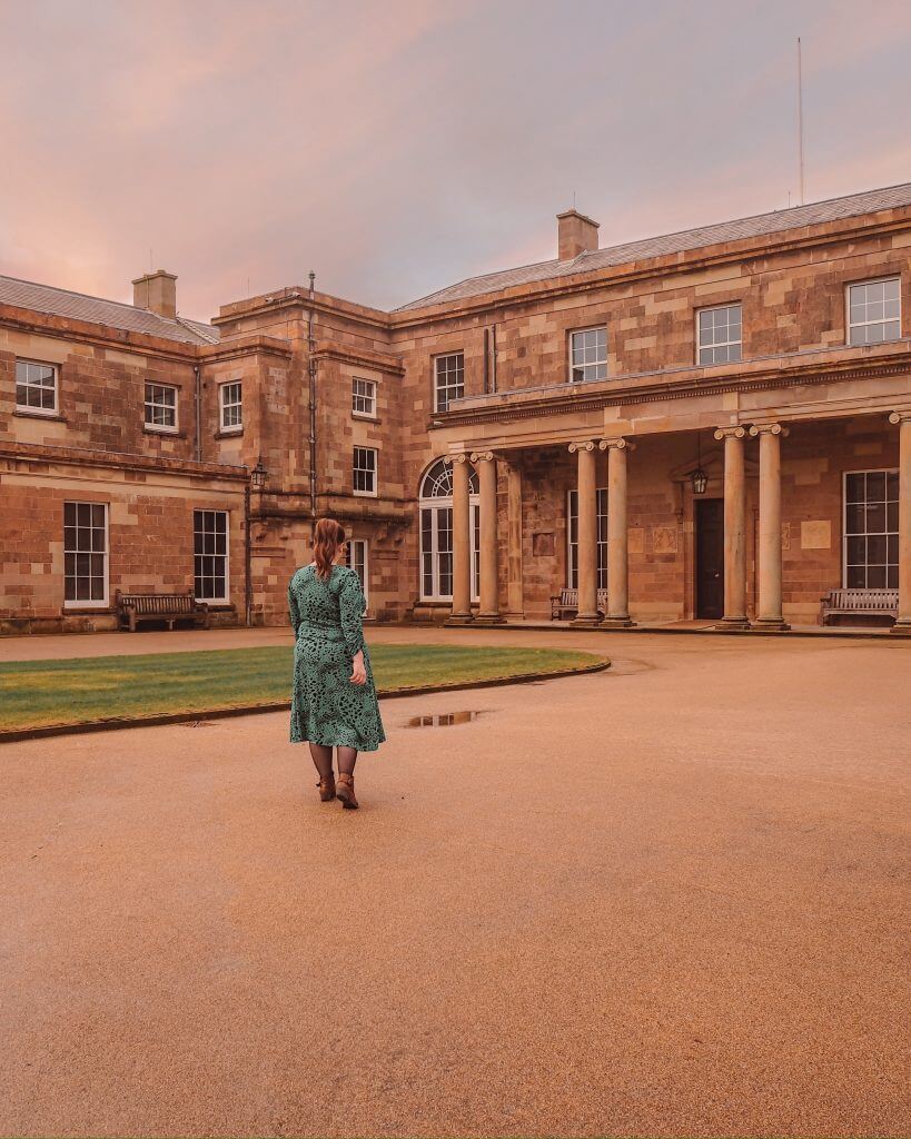 Woman in a green dress standing on the grounds of Northern Ireland Castle in the village of Hillsborough