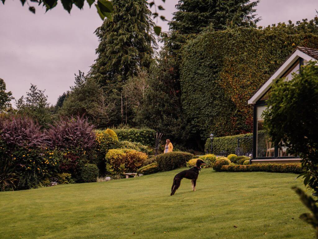Woman in a yellow raincoat exploring Shekina Sculpture Gardens
