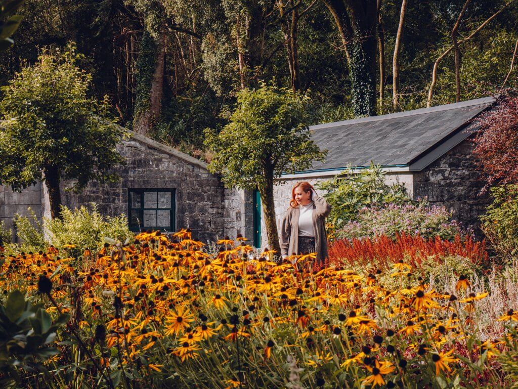 Woman exploring the flower gardens at a luxury five star hotel in Ireland