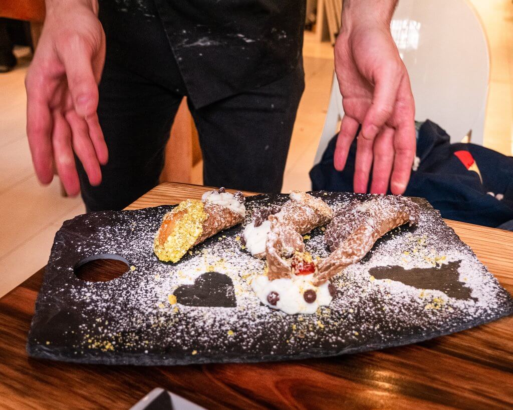 Man serving a tray of hot chocolate and cannoli on a walking tour Belfast