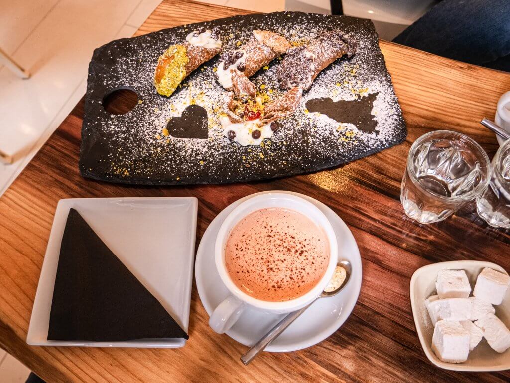 Cup of hot chocolate and a plate of cannoli dessert