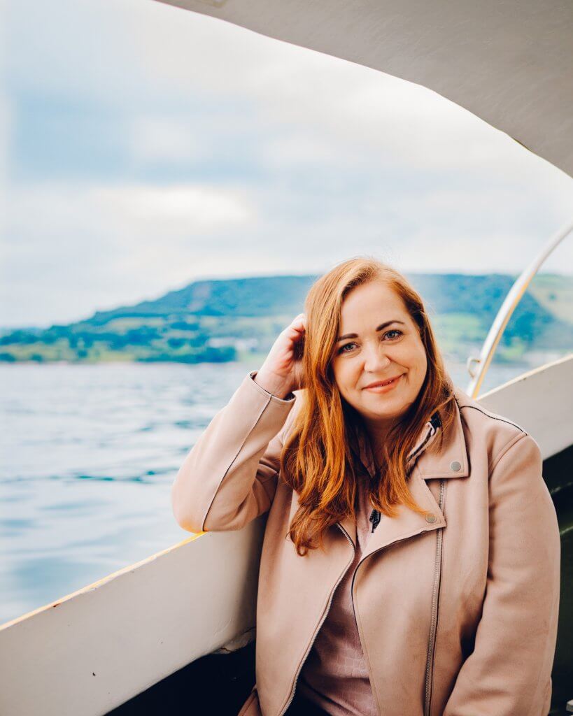 Woman sitting on a boat in Carnlough Harbour in Antrim Northern Ireland
