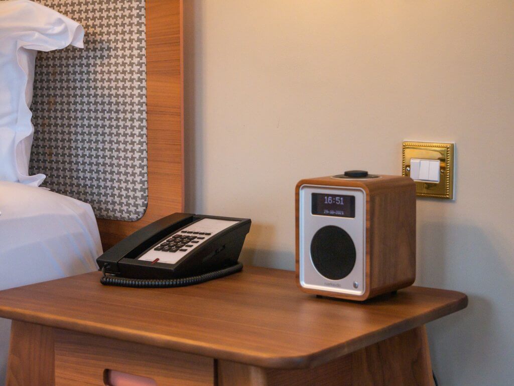Wooden, vintage alarm clock sits on a bedside locker in a Signature Suite in Sheen Falls Lodge, one of Ireland's bext hotels.