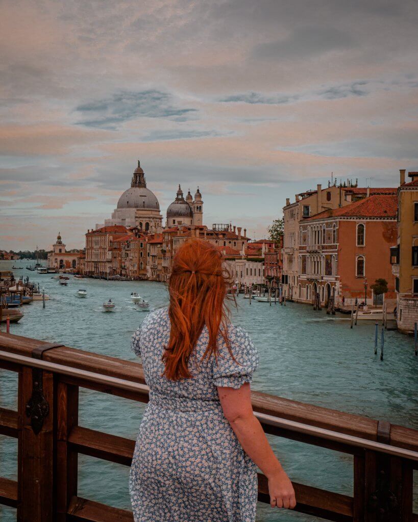 Woman looking at the view of Venice Italy from Ponte dell'Accademia the perfect Instagram spot in Venice