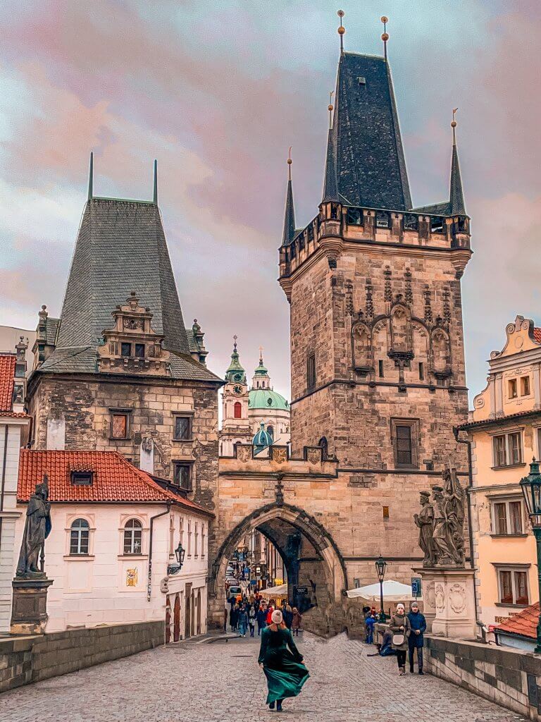 Woman in a green velvet dress at Charles Bridge an iconic photo spot in Prague