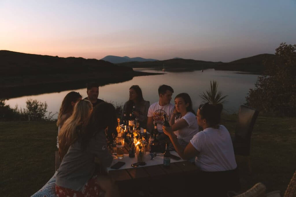 A group of friends having dinner at Collanmore Island Lodge airbnb in Ireland