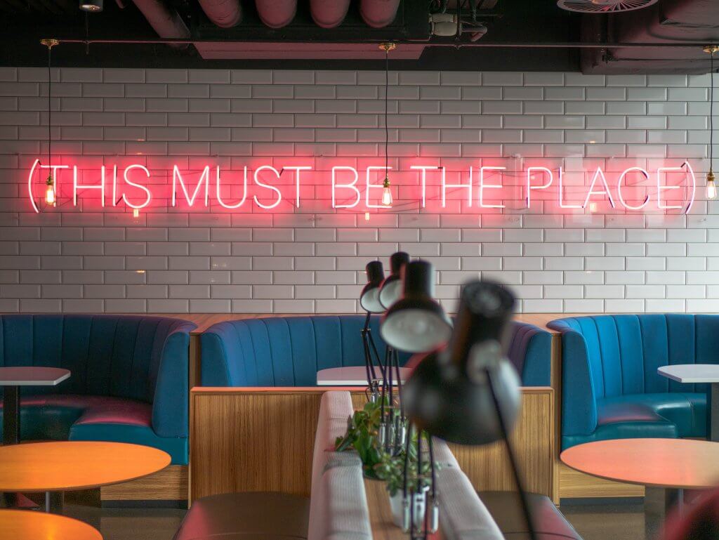 Breakfast room with a neon sign saying this must be the place in Aloft Dublin City