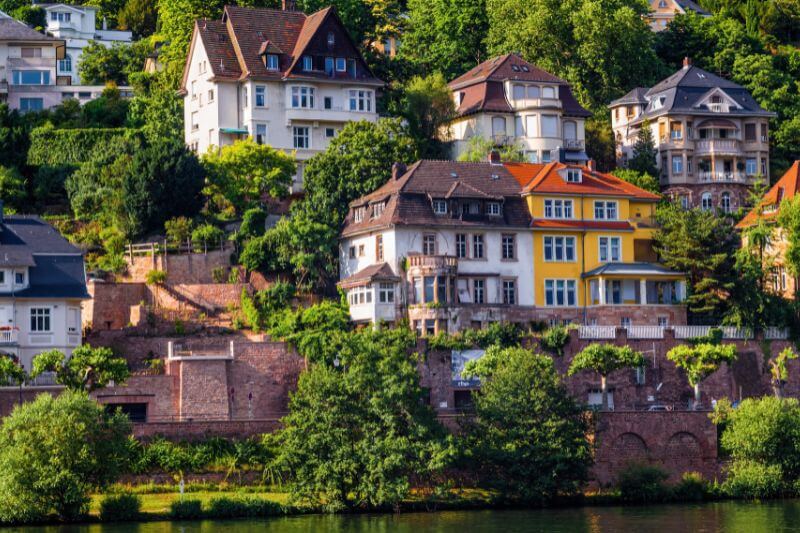 A postcard-perfect view of Heidelberg Castle with the Neckar River flowing in the foreground.