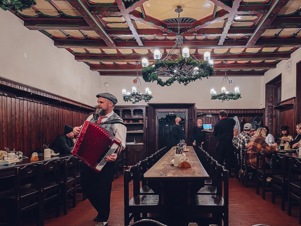 Man playing an accordion at U Flecku restaurant in Prague