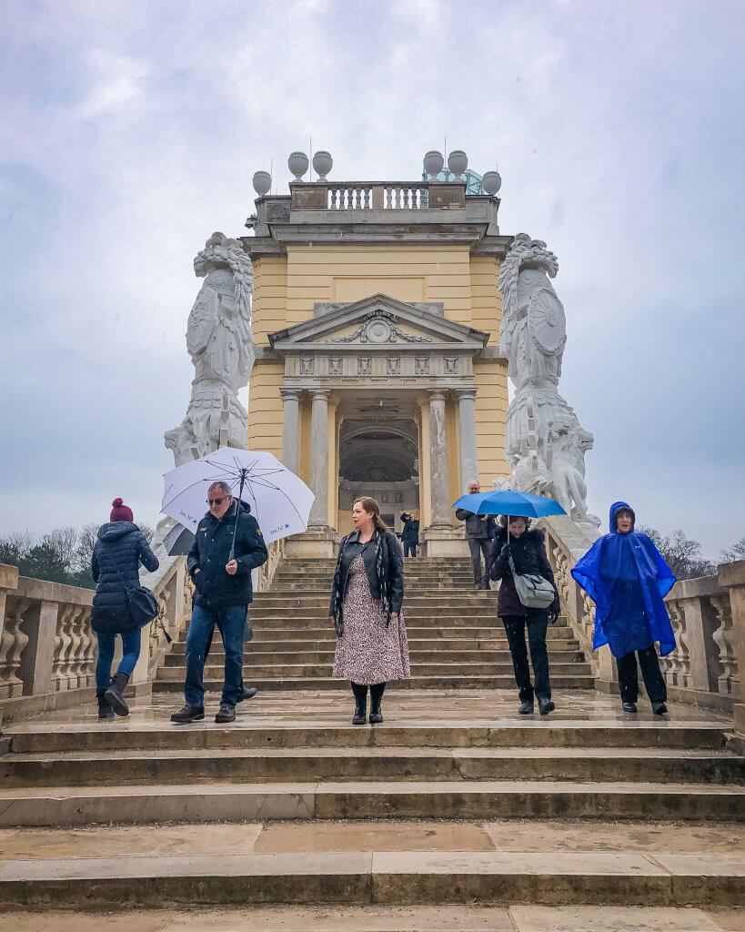 People walking in the rain at Gloriette in Schonbrunn Palace in Vienna