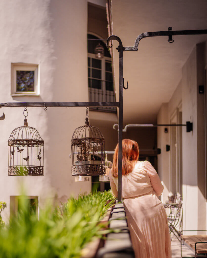 Woman resting on the railings of the courtyard of MOOo by the castle apartments during a 2 day stay in Prague