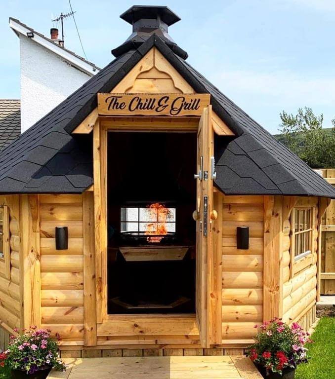 The Chill & Grill communal meeting place in Benone Getaways. A wooden lodge with a fire pit.