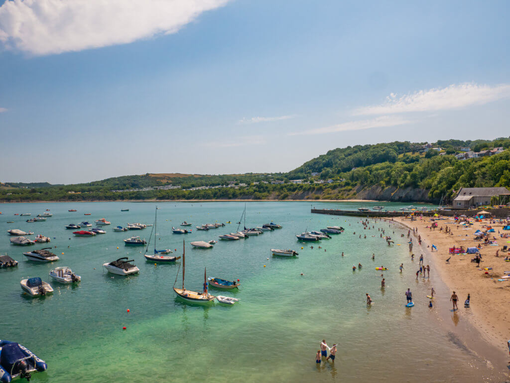 People enjoying the sunshine in New Quay beach in Cardigan Bay along the celtic routes in West Wales