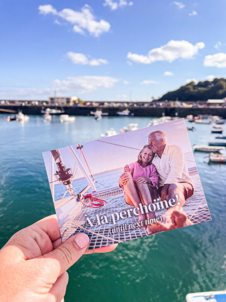 Woman holding up a postcard at the port of Guernsey