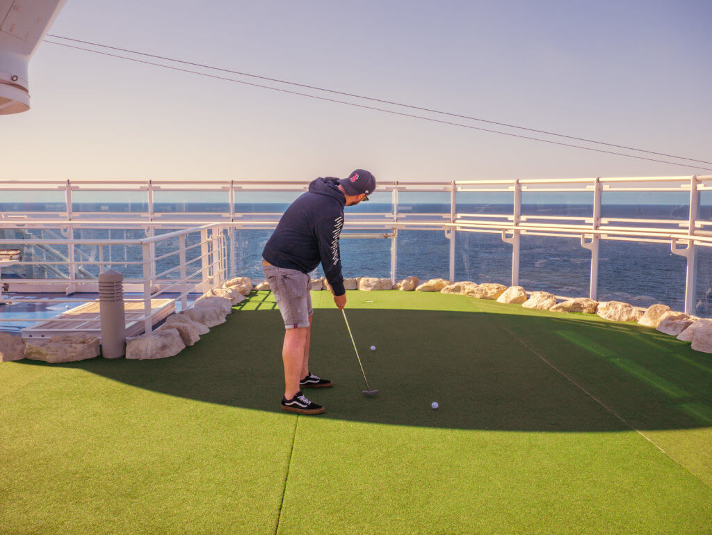 Man playing golf on the putting green onboard Sky Princess Cruise Ship