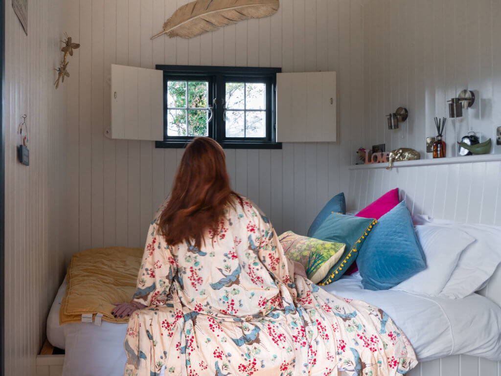Woman relaxing on a bed in a robe on a romantic autumn break in Ireland
