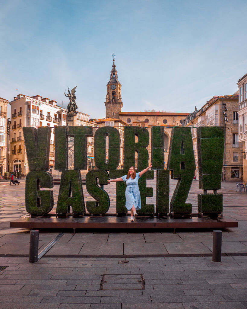 Vitoria Gasteiz Woman in a blue dress having her photo taken in front of the grass Vitoria Gasteiz sculpture