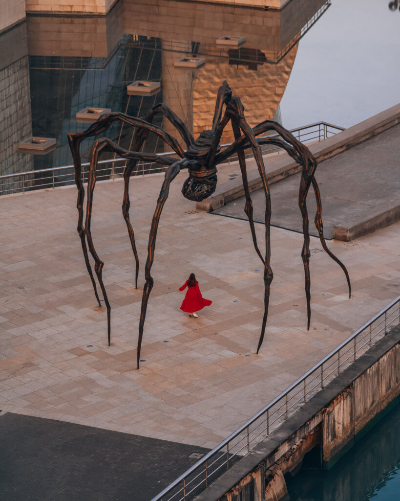 Nicola Lavin, travel writer with Our Unique Stays, stands under the spider sculpture 'Maman' at the Guggenheim museum in Bilbao