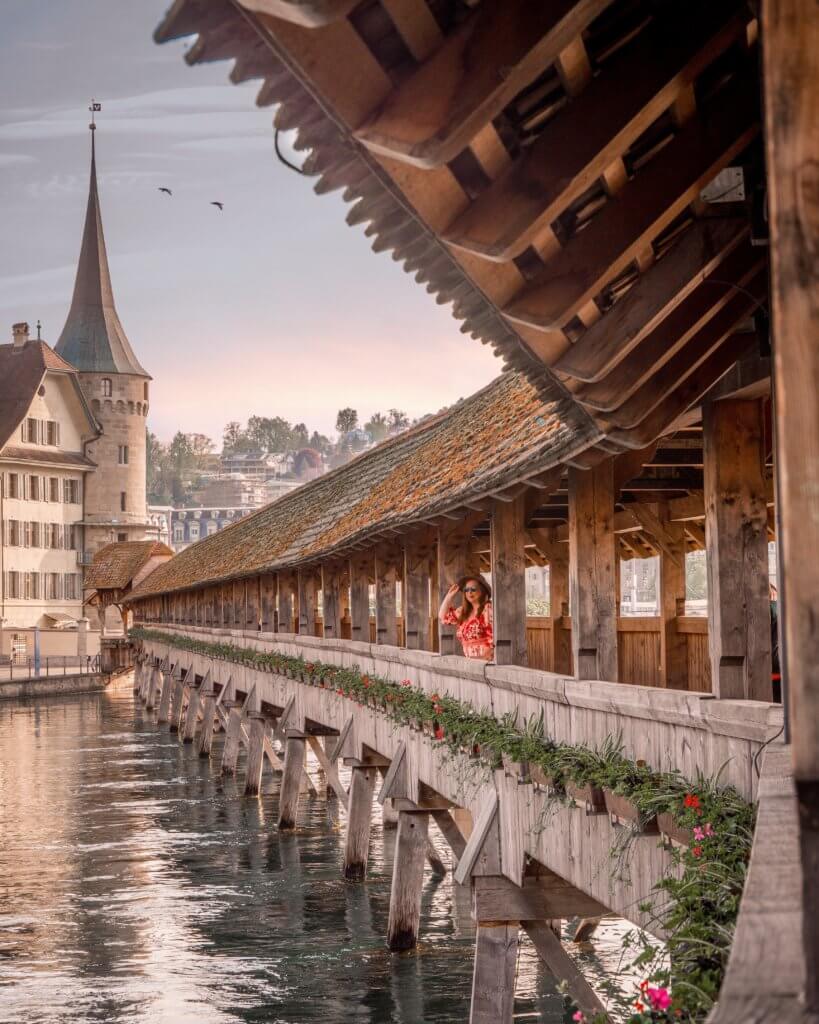 Nicola Lavin, travel writer with Our Unique Stays, stands on the wooden chapel bridge in Lucerne