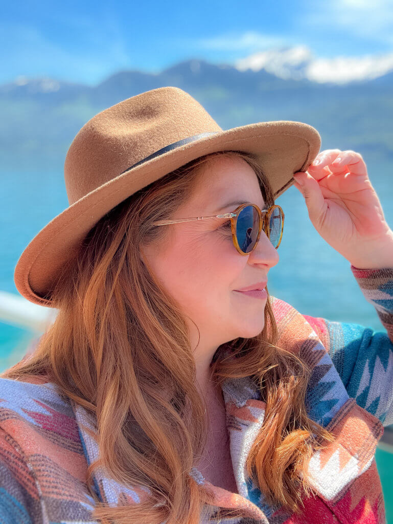 Nicola Lavin, travel writer for Our Unique Stays, wears sunglasses and hat and enjoys the views on the Gotthard Panorama Express