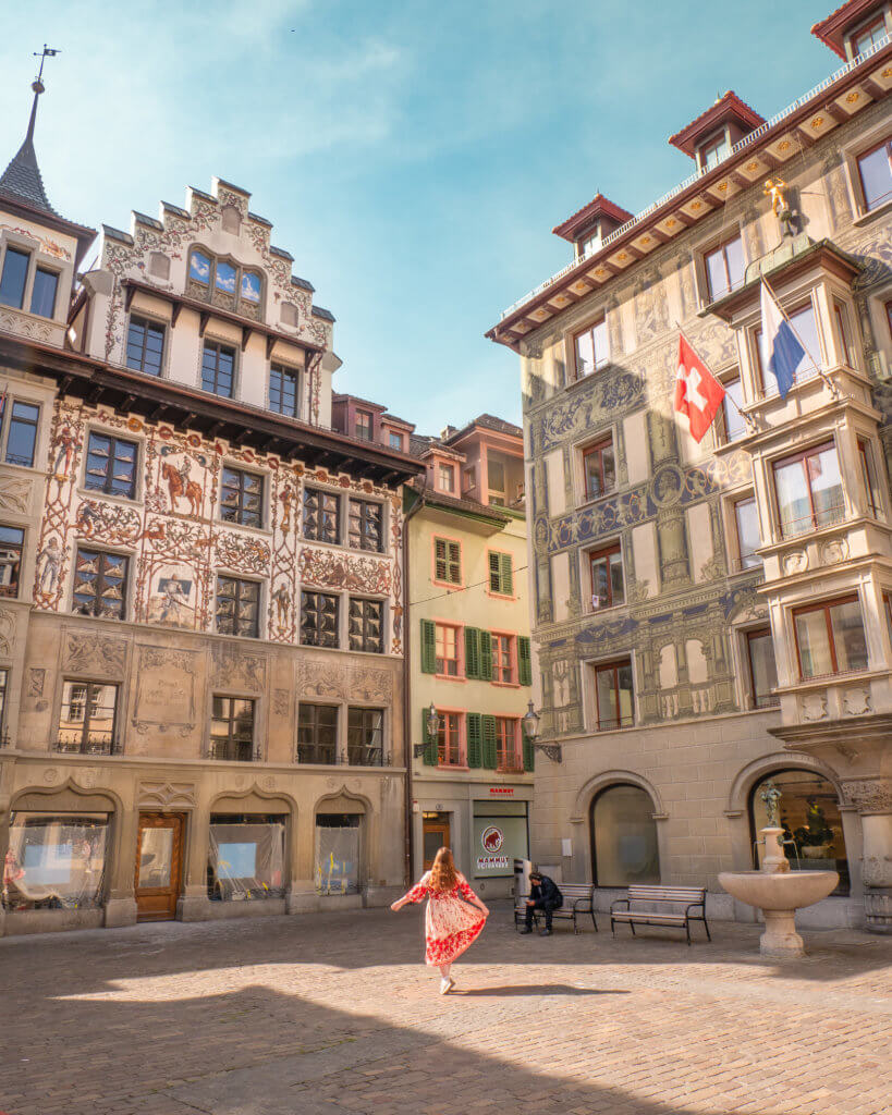 Nicola Lavin, travel blogger with Our Unique Stays, twirls in Weinmarkt in Lucerne Old Town during one day in Lucerne.