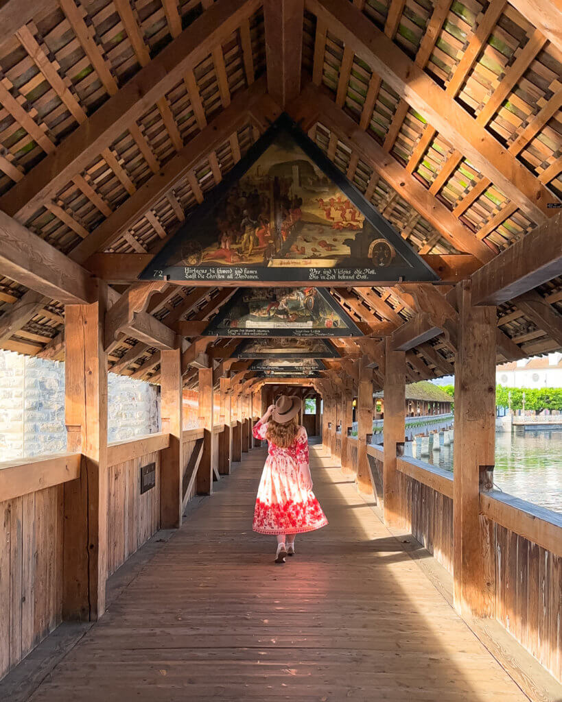 Nicola Lavin. Travel Blogger with Our Unique Stays, walks on the famous wooden Chapel Bridge in Lucerne Switzerland during one day in Lucerne.
