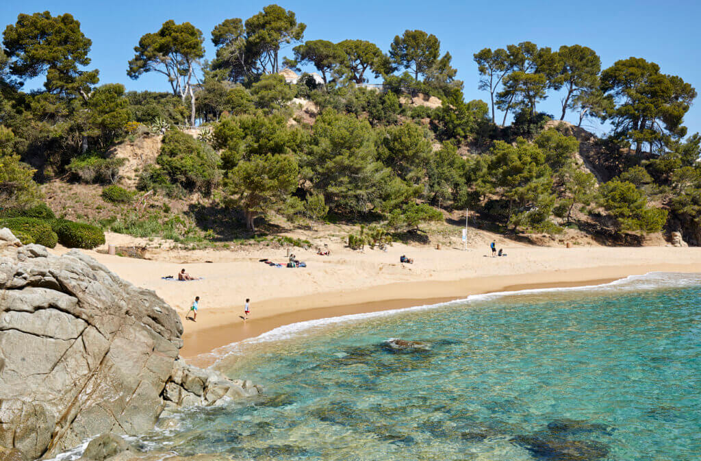 Family playing on Treumal Beach on the Costa Brava