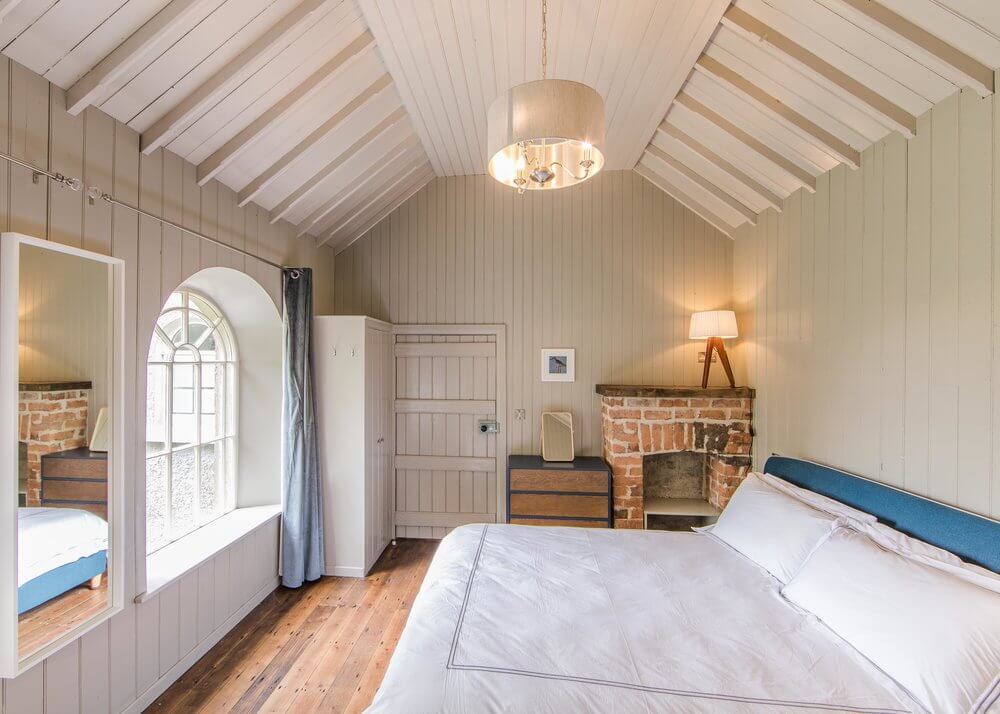 Bedroom at Quarry Hill Church a unique place to stay in Northern Ireland. Decor is white timber walls in farmhouse style.