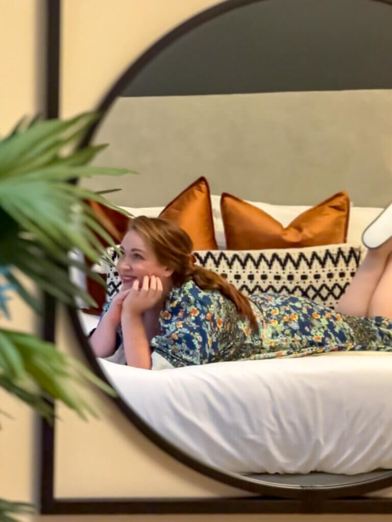 Woman wearing a dressing gown relaxing on a bed in Corrstown Village in Northern Ireland