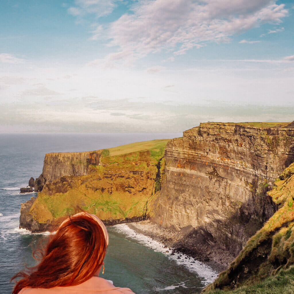 Nicola Lavin of Our Unique Stays stares out at the ocean from the Cliffs of Moher