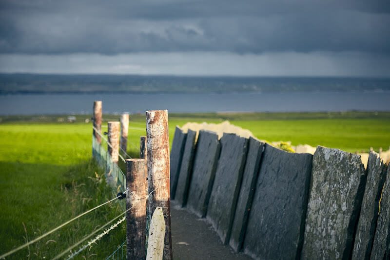 Image of stone slates lining the walkway, making a path for hikers expolring the Cliffs of Moher, Ireland.