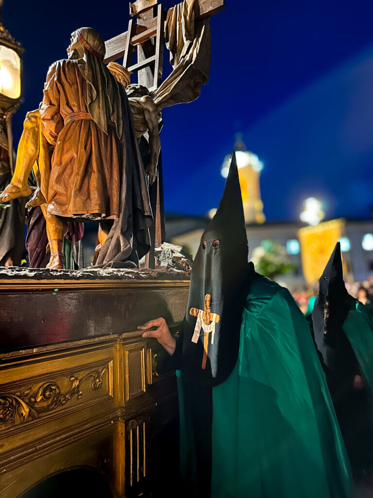 Mesmerizing Easter parade in Seville: a procession of hooded figures carrying ornate floats.