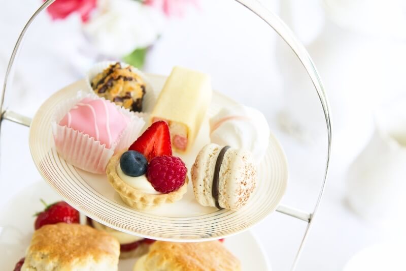 Cakes and baked goods on a cake stand served during afternoon tea in the Cotswolds.