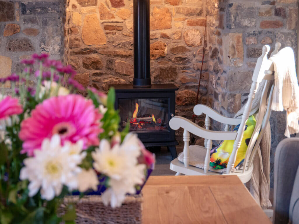 Wooden rocking chair beside a stove in Meadow View Farmhouse in Tipperary.