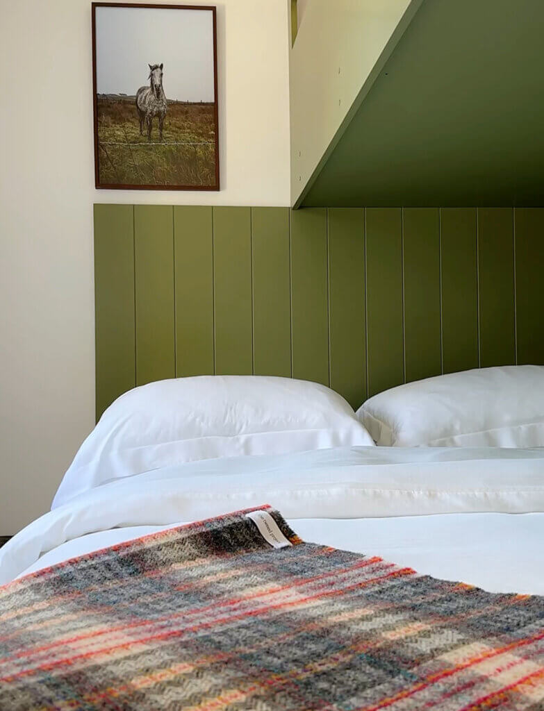 Bedroom in Within the Village, Roundstone, furnished with Irish linen and tweed and curated art.