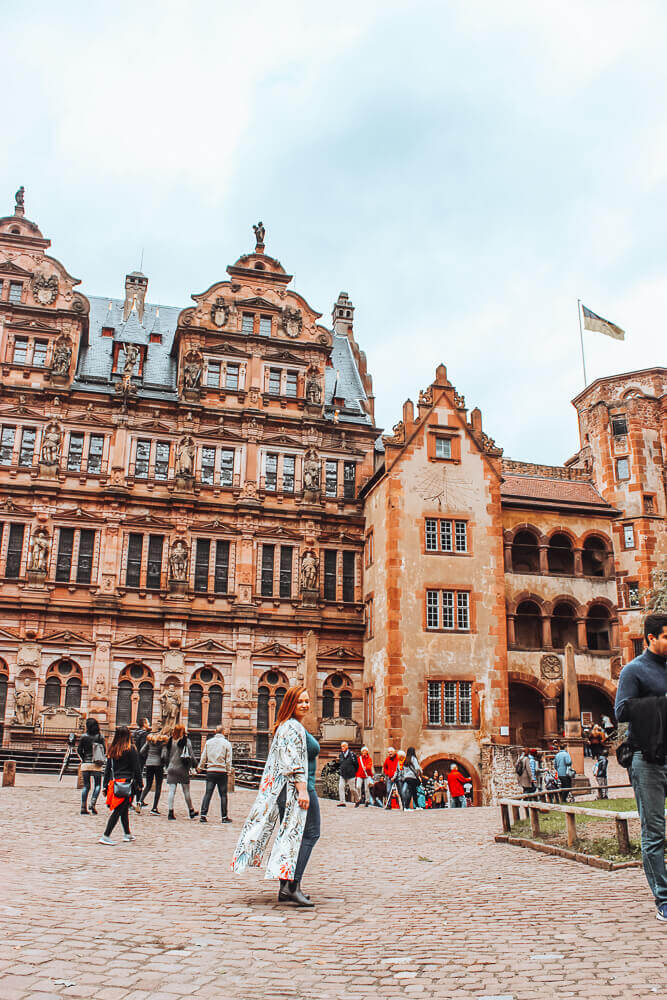 A woman visiting the courtyard of Heidelberg castle one of the best things to do in 1 day in Heidelberg